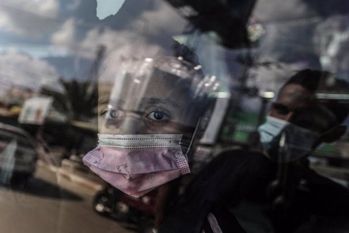 FILED - 16 November 2020, Palestinian Territories, Deir Al Balah: A Palestinian girl wearing a mask looks out of the car window. Photo: Ashraf Amra/APA Images via ZUMA Wire/dpa