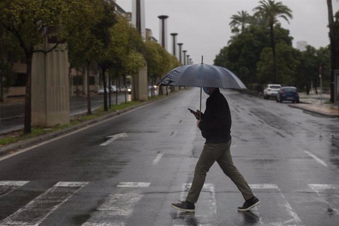 Un hombre camina protegido de la lluvia con un paraguas. Las ciudades andaluzas Córdoba, Sevilla, Huelva, Cádiz y Málaga tienen hoy aviso amarillo por acumulaciones de las precipitaciones que podrán llegar a los 25 litros por metro cuadrado en una hora.