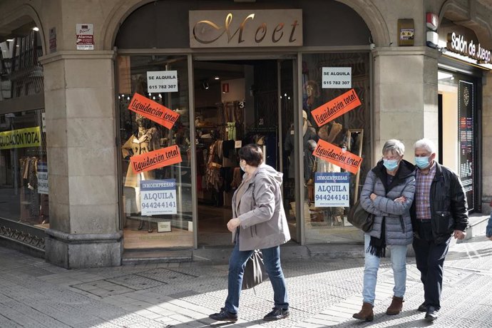 Transeúntes caminan al lado de un establecimiento de Bilbao un día después de la petición del Gobierno vasco de la declaración del estado de alarma debido al aumento de casos de Covid-19, en Bilbao, Vizcaya, País Vasco, (España), a 24 de octubre de 2020.