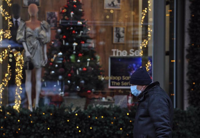 Un hombre con mascarilla ante un escaparate en Kiev