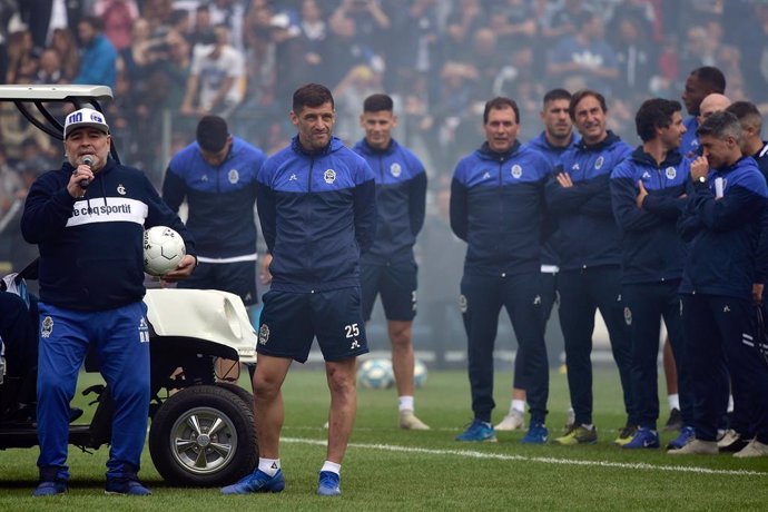 08 September 2019, Argentina, La Plata: Argentine former footballer Diego Maradona (L) holds a soccer ball as speaks to the fans alongside with assistants and players of Argentina's club Gimnasia y Esgrima La Plata during his presentation as the team's 