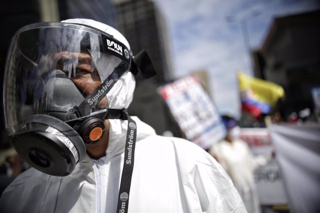 Un hombre con un traje de protección durante una protesta en Bogotá