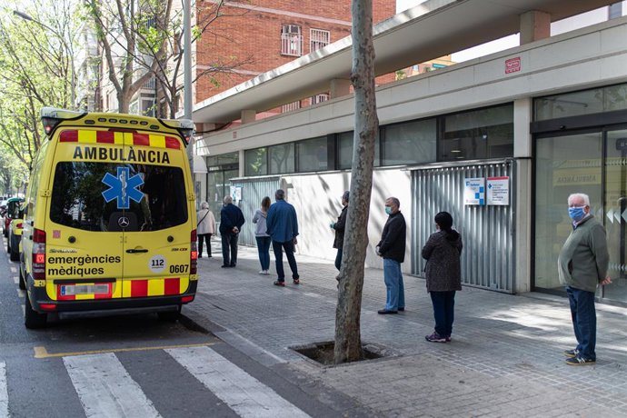 Diverses persones fan cua respectant la distncia de seguretat per entrar en un ambulatori al costat de l'Ambulncia de Sistema d'Emergncies Mdiques (SEM) de la Generalitat de Catalunya, a Barcelona/Catalunya (Espanya) a 19 d'abril del 2020.