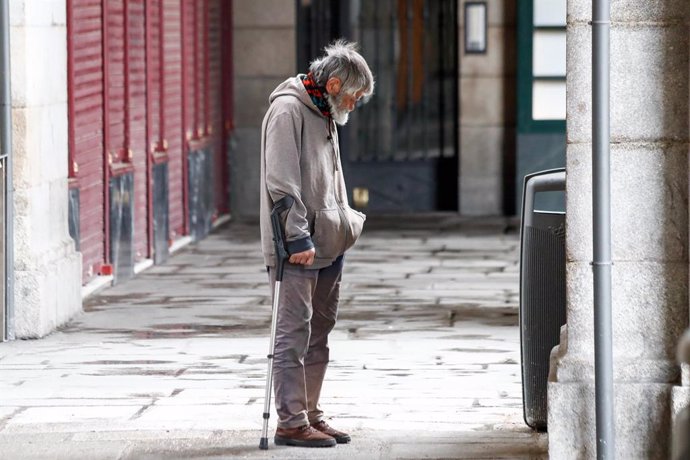 Un hombre sin hogar camina por los soportales de la Plaza Mayor durante el primer día de la cuarta semana de estado de alarma decretado por el Gobierno para combatir el coronavirus, en Madrid (España) a 6 de abril de 2020.