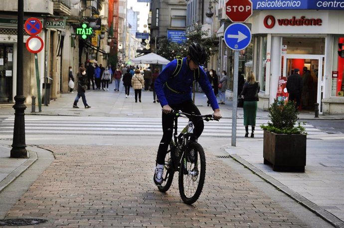 Unha persona circula en bicicleta por unha vía do centro o mesmo día en que se levanta o peche perimetral do municipio e reábrese a hostalaría, no Carballiño, Ourense, Galicia, (España), a 21 de novembro de 2020. Esta nova fase de desescalada se 