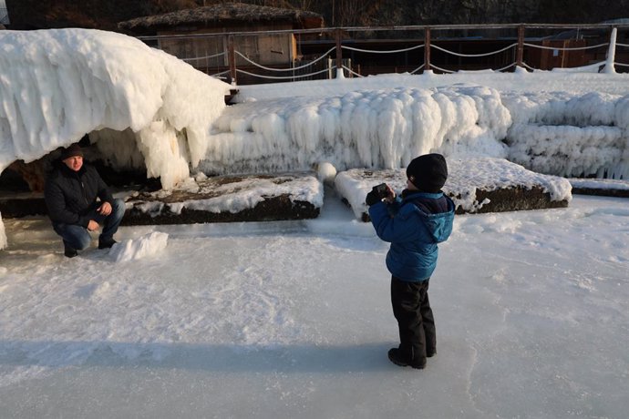 Imagen de archivo de un hijo fotografiando a su padre en un río congelado en Vladivostok, en el extremo oriental de Rusia