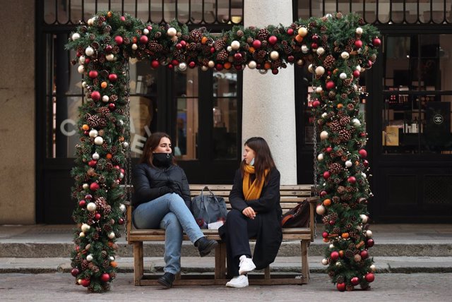 26 November 2020, England, London: Two women sit on a bench festively decorated with the Christmas Baubles, in Covent Garden. Photo: Yui Mok/PA Wire/dpa