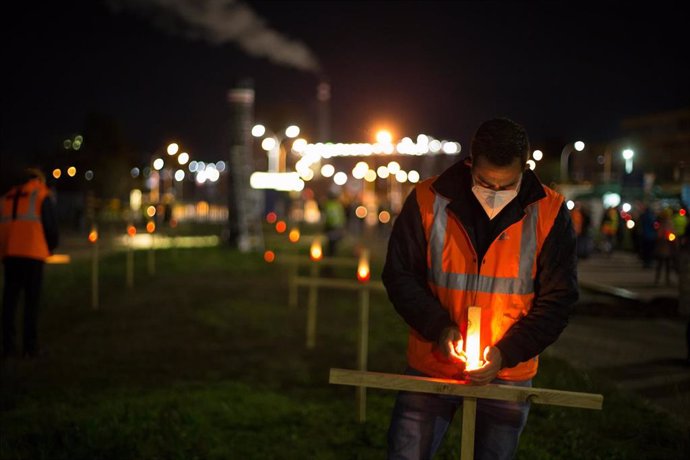 Un trabajador de la fábrica coloca una vela durante un velatorio nocturno simbólico convocado por la fábrica de Alcoa, en  en San Cibrao, A Mariña.