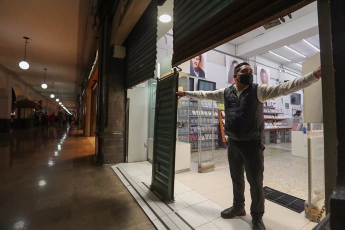 23 November 2020, Mexico, Toluca: A man closes a shop in implementation of government decisions to close shops at 7 pm to curb the spread of the coronavirus (Covid-19). Photo: -/El Universal via ZUMA Wire/dpa