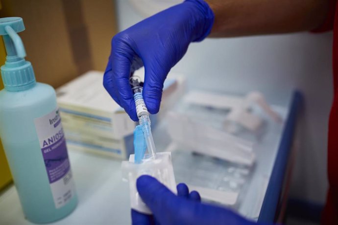 Un sanitario de Cruz Roja se prepara para administrar la vacuna contra la gripe en un punto de vacunación instalado en Aranjuez.