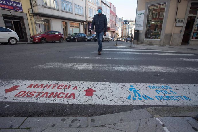 Una persona cruza un paso de cebra el mismo día de la entrada en vigor de nuevas restricciones impuestas por la crisis del Covid-19 en el municipio de Vilalba, Lugo, (España), a 21 de noviembre de 2020. Entre las medidas, además del cierre perimetral, s