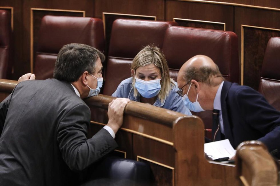 El portavoz del PNV en el Congreso de los Diputados, Aitor Esteban, habla con sus compañeros de grupo Idoia Sagastizabal y Mikel Legarda, durante una sesión plenaria