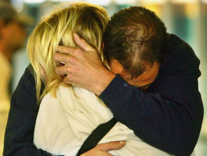 A weeping couple embace after laying a floral tribute at King's Cross Station on July 8, 2005 in London, England. More than 50 people were killed and 700 injured during a series of explosions in the morning rush hour the previous day.