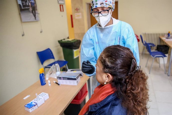 Una sanitaria realiza un test de antígenos a una mujer en un dispositivo organizado por la Comunidad de Madrid