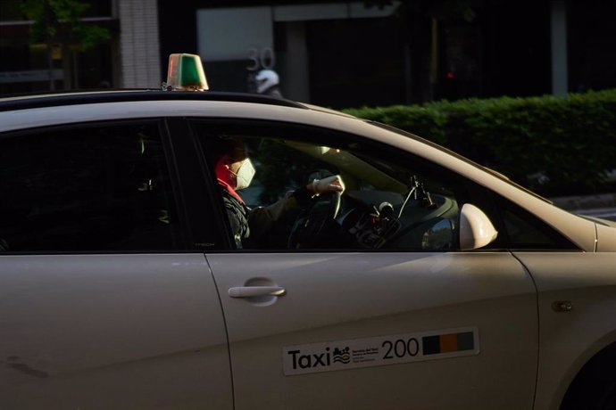 Foto de archivo de un taxista con mascarilla conduce su taxi un día después de que el Gobierno anunciara las medidas de desescalada por la pandemia del coronavirus, en Pamplona (Navarra) a 29 de abril de 2020.
