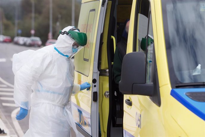 Un traballador sanitario totalmente protexido pecha a porta dunha ambulancia após recoller a un ancián da residencia de anciáns de San Cibrao onde se orixinou un brote de Covid-19, en San Cibrao, Lugo, Galicia, (España), a 9 de novembro de 20
