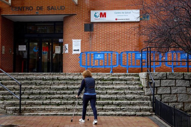 Una mujer sube con una muleta las escaleras del Centro de Salud de Colmenar Norte en Colmenar Viejo.