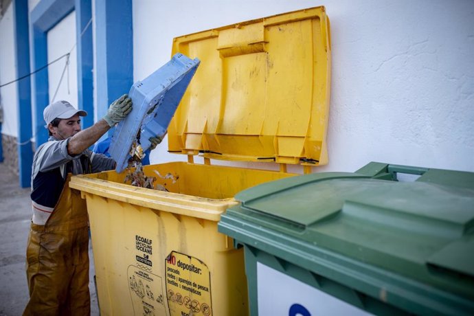 Un pescador depositando residuos recuperados