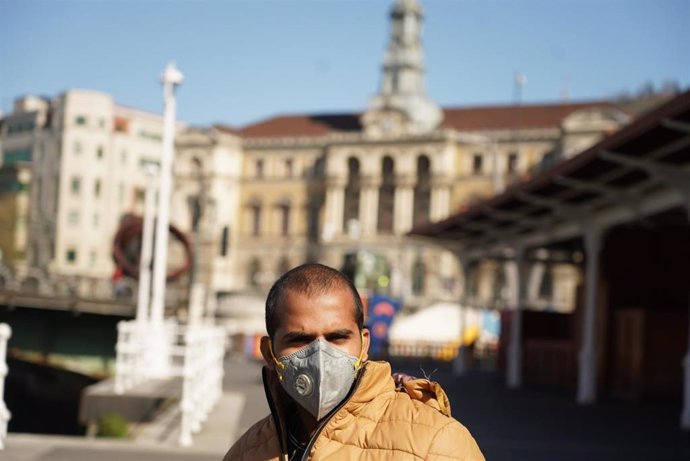 Un hombre pasea protegido con mascarilla por Bilbao tras el anuncio de Estado de Alarma de marzo