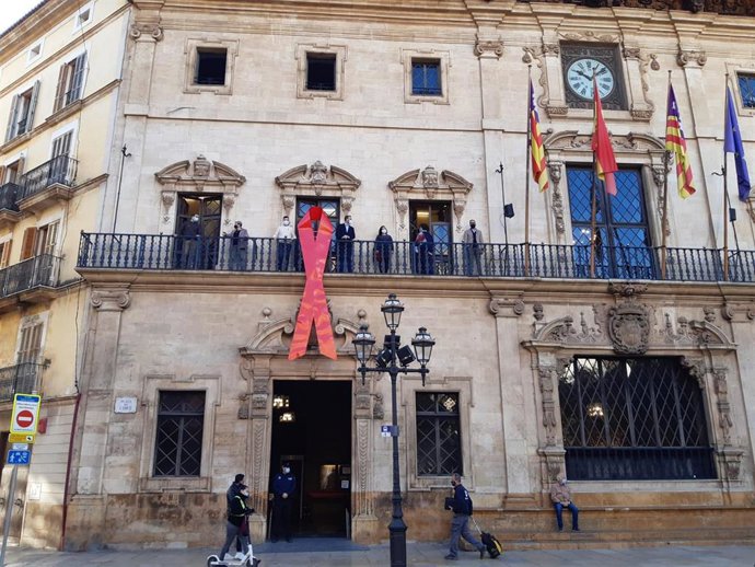 Lazo rojo de la lucha contra el sida, en la fachada de Cort.