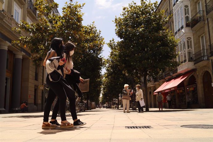 Dos jóvenes pasean con mascarilla por una céntrica calle de Vitoria-Gasteiz, Álava