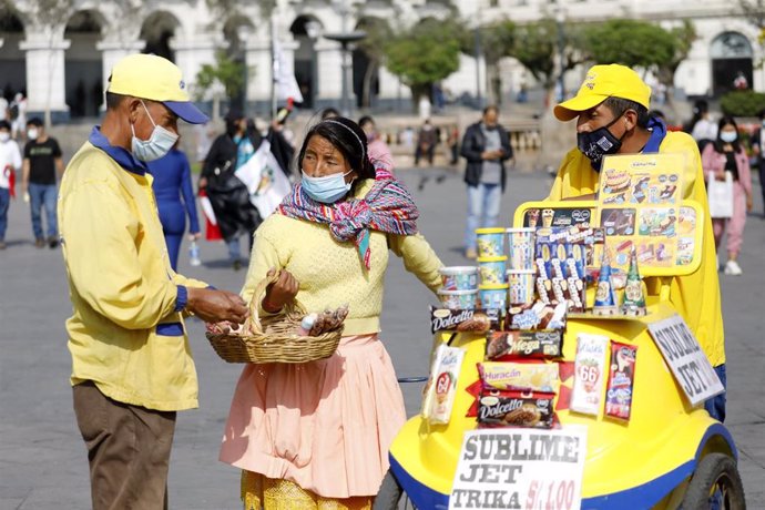 Personas con mascarilla en una plaza de Lima