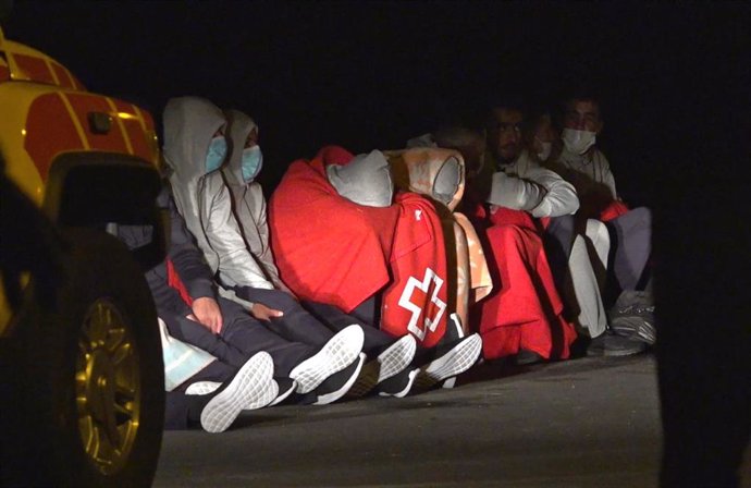 Tapadas con mantas de Cruz Roja. algunas de las 27 personas que lograron llegar a tierra con vida tras el vuelco de la patera en la que viajaban, en Lanzarote, Canarias (España), a 24 de noviembre de 2020. 