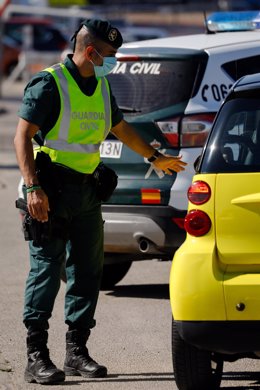 Un agente de la Guardia Civil le da el alto a un pasajero durante un control de movilidad en Alguazas, Murcia (España)