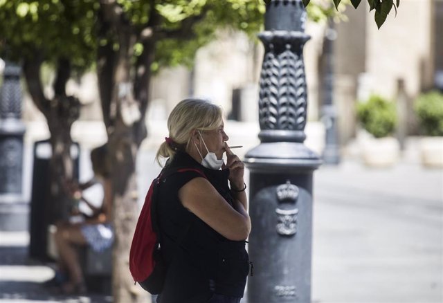Una persona fuma en la calle, foto de archivo