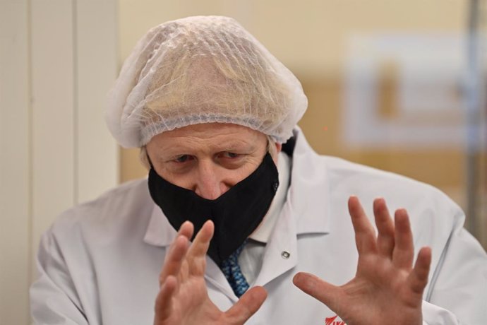 30 November 2020, Wales, Wrexham: UKPrime Minister Boris Johnson watches quality testing at the 'fill and finish' stage of the manufacturing process of Covid-19 vaccines, during a visit to Wockhardt's pharmaceutical manufacturing facility following the