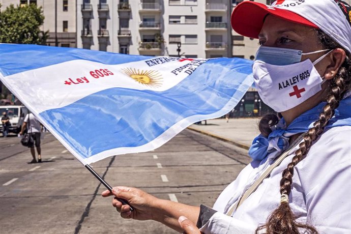 Imagen de archivo de una mujer con mascarilla y la bandera de Argentina en una protesta para exigir mejores condiciones laborales para los trabajadores médicos.