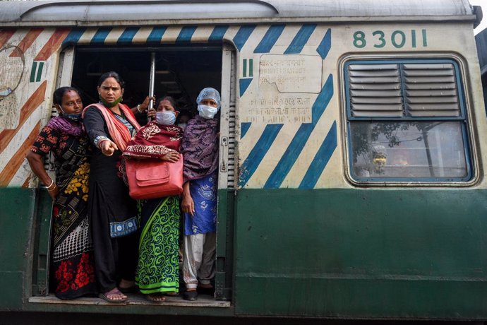 26 November 2020, India, Kolkata: Passengers stand in the train and express their opposition to the strike across India and the railway blockades during a protest calling for a nationwide strike against the current Indian governments' policies against t