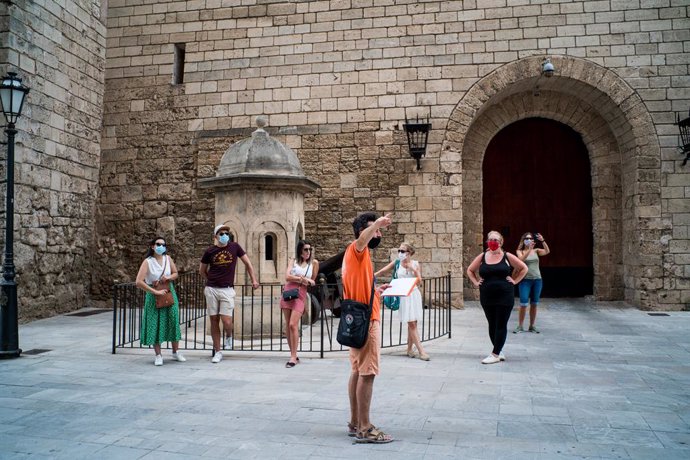 Varios turistas junto al Palacio de la Almudaina de Palma en julio.