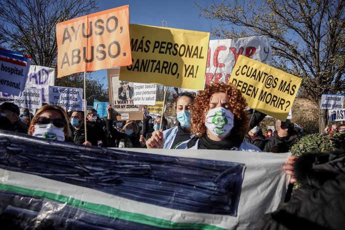 Varias personas se manifiestan con pancartas durante una concentración convocada por la plataforma Sanitarios Necesarios en la puerta del Hospital Enfermera Isabel Zendal
