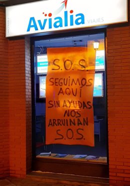 Una de las agencias de viajes de Huelva solicita públicamente ayuda a través de un cartel en su escaparate.
