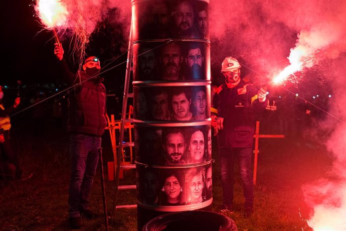 Varios trabajadores sostienen bengalas durante un velatorio nocturno simbólico convocado por la fábrica de Alcoa, en  en San Cibrao, A Mariña, Lugo, Galicia (España), a 28 de noviembre de 2020. 