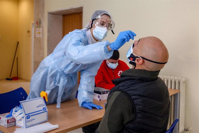 Una sanitaria realiza un test de antígenos a un hombre en un dispositivo organizado por la Comunidad de Madrid