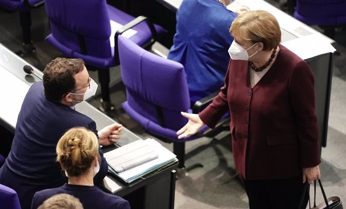 Merkel dialoga con el ministro de Sanidad de Alemania, Jens Spahn, en el Bundestag