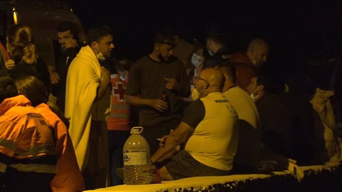 Tapadas con mantas de Cruz Roja. algunas de las 27 personas que lograron llegar a tierra con vida tras el vuelco de la patera en la que viajaban en la noche de este martes,  en la costa de Órzola, en la zona de La Condesa, en Lanzarote, Canarias (España