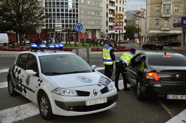 Dos agentes paran a un vehículo en un control realizado en O Carballiño, Ourense.