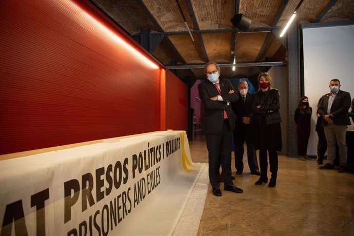 El expresidente de la Generalitat, Quim Torra, observando la pancarta a favor de los presos del 1-O por la que fue inhabilitado, en el acto de entrega de dicha pancarta al Museu d'Histria de Catalunya