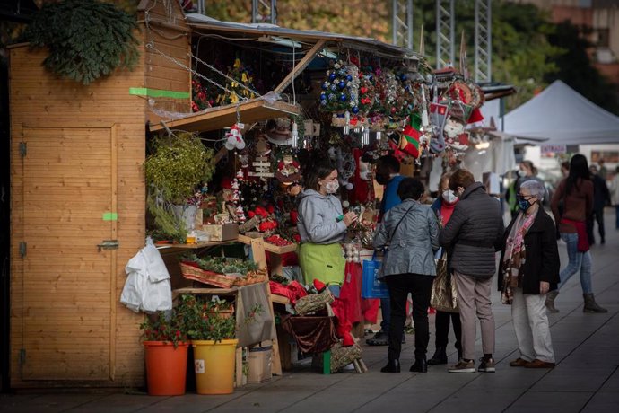 Tres señoras en uno de los 121 puestos que este año forman parte de la 'Fira de Santa Llúcia', el mercado de Navidad más antiguo de Barcelona, Catalunya (España), a 30 de noviembre de 2020. Este año la feria dispondrá de 121 puestos en lugar de las 280 