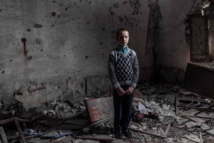 Un niño en una escuela destruida por el conflicto en el este de Ucrania