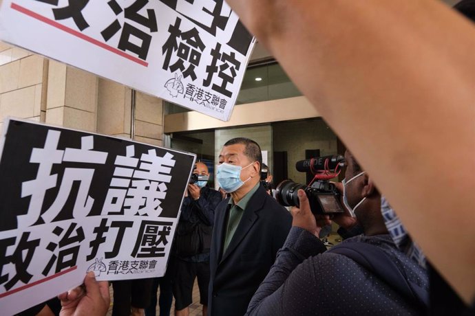 03 November 2020, China, Hong kong: Activists and supporters hold placards as pro-democracy media tycoon Jimmy Lai arrives at West Kowloon Magistrates' Court where he and 26 Hong Kong pro-democracy activists, are being accused of taking part in an illeg
