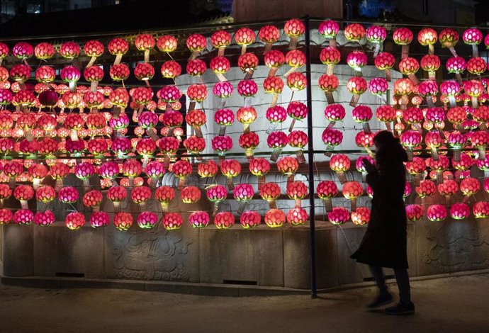 Una mujer reza en el Templo Jogyesa por un miembro de su familia que se presenta al examen de acceso a la universidad en Seúl, Corea del Sur.