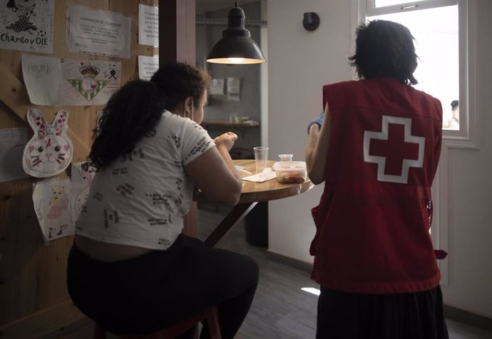 Una voluntaria de Cruz Roja con una comensal en el comedor del centro situado en la calle Atocha para personas vulnerables habilitado por la Comunidad de Madrid y gestionado por Cruz Roja, a 2 de julio de 2020.