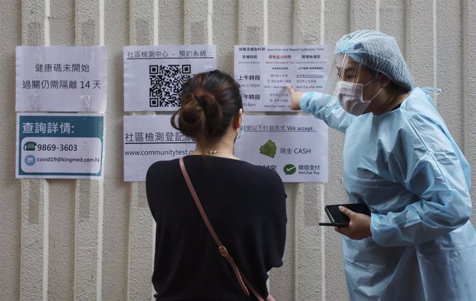 Personal médico de Hong Kong da indicaciones a quienes se acercan a sus instalaciones para someterse a una prueba de COVID-19.