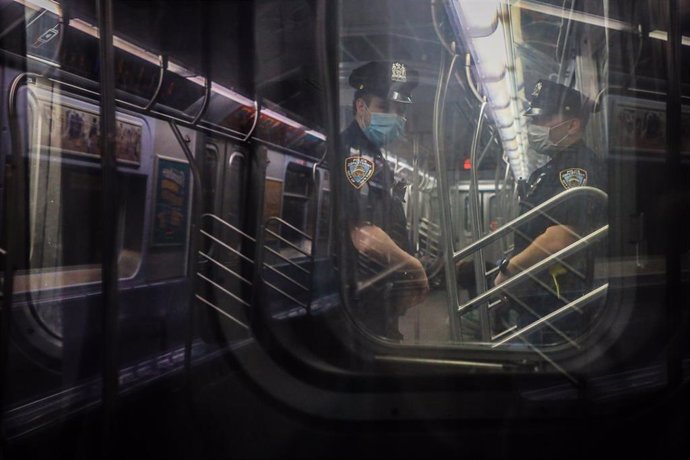 Dos policías con mascarilla en un tren del metro de Nueva York