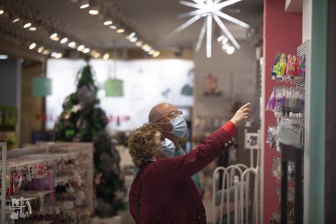Dos personas compran en una tienda ya decorada con motivos navideños. En Sevilla , (Andalucía, España), a 17 de noviembre de 2020.