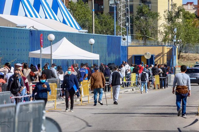 Varias personas esperan en una cola para tramitar papeles de Extranjería en el Centro de Internamiento de Extranjeros (CIE) de Aluche